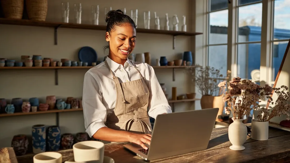 A self-employed shop owner reviewing her loan options on a laptop