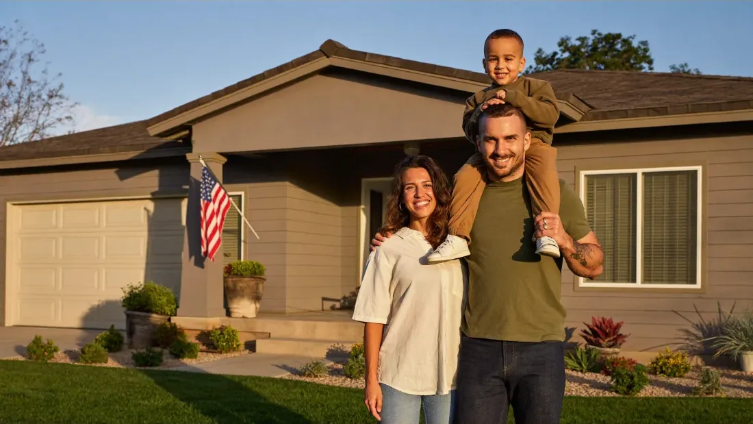 A veteran and his family in front of their new home